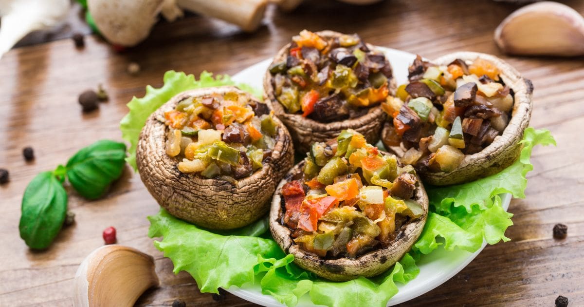 A plate of stuffed portobello mushrooms with meat and vegetables.