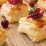 A close-up of a cranberry brie bites on a wooden plate.