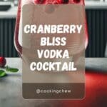A glass of cranberry bliss vodka cocktail, a red cocktail garnished with a sugared cranberry.