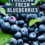 A photo of a colorful assortment of fresh blueberries scattered on a rustic wooden table.