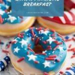 A round donut with red, white, and blue frosting and sprinkles sits on a plate.