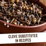 A close-up photo of a bowl filled with cloves on a table.