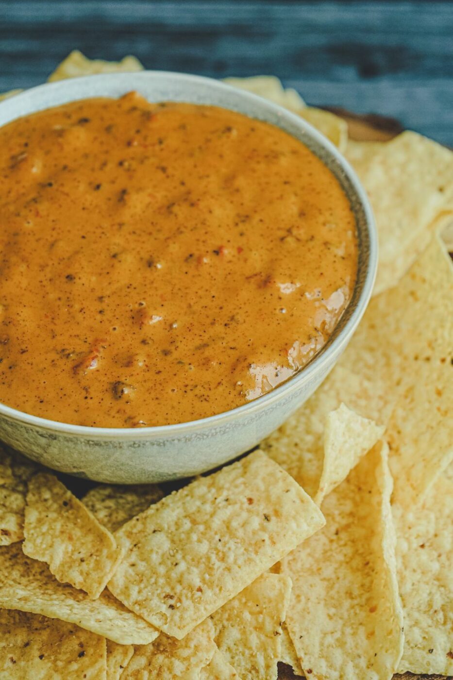 A bubbly, hot chili cheese dip with Velveeta, served in a cast iron skillet with tortilla chips.