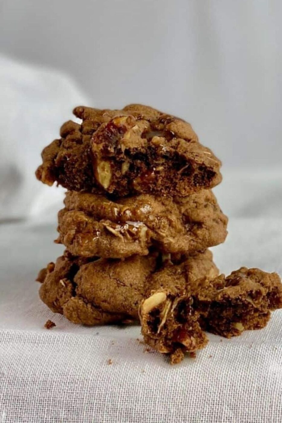  A plate of rich German chocolate cookies with visible coconut and pecan, some possibly drizzled with chocolate.