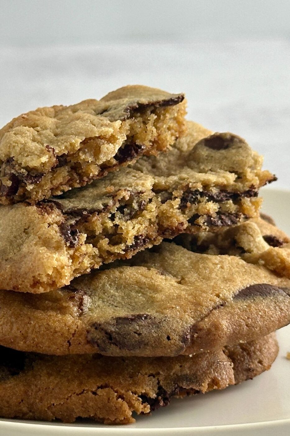 A pile of soft and chewy chocolate chip cookies with visible Ghirardelli chocolate chips.