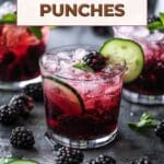 A glass of boozy blackberry cucumber gin spritzer on a table.