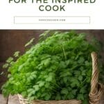 A wicker basket filled with fresh chervil on a wooden table.
