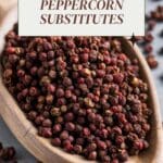 A heaping wooden spoon overflowing with vibrant red Sichuan peppercorns.