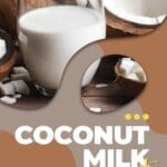 A glass of coconut milk sits beside a half-cut coconut on a wooden table.