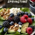 A close-up photo of a colorful and nutritious salad made with berries, avocado, and nuts.