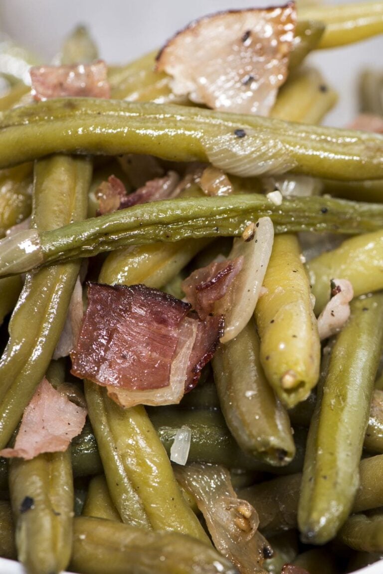A serving of green beans cooked in the style of Texas Roadhouse, with visible seasoning and broth.