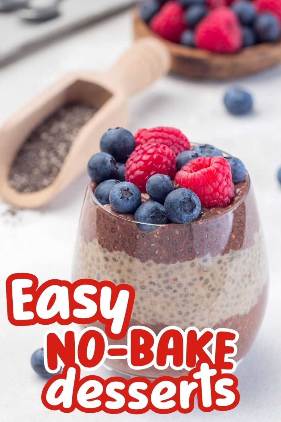 A clear glass cup of chocolate chia pudding topped with fresh berries