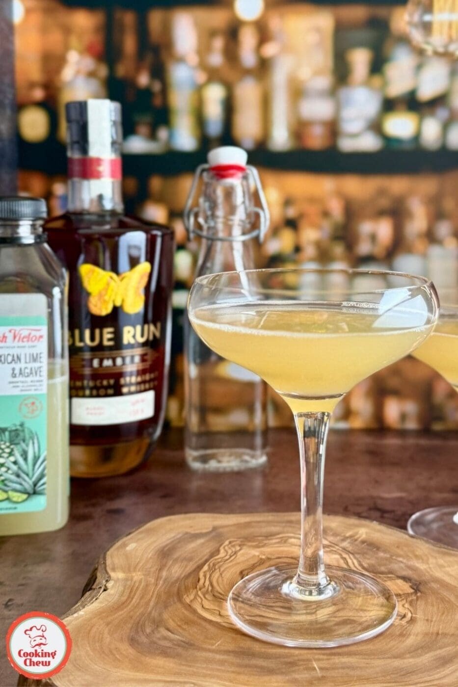 A Bourbon Lime Sour cocktail served in a chilled glass next to Fresh Victor mixers and Blue Run Ember bourbon
