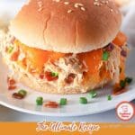 A creamy crack chicken dish garnished with bacon and shredded cheese.