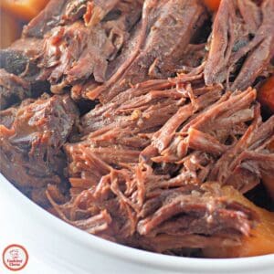 A slow cooker filled with beef roast and tender vegetables.