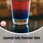Stunning layered Jolly Rancher shots in shot glasses with vibrant red, blue, and green hues.