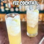 A glass of jalapeño lime cocktail with ice, garnished with a lime wedge and jalapeño slices.