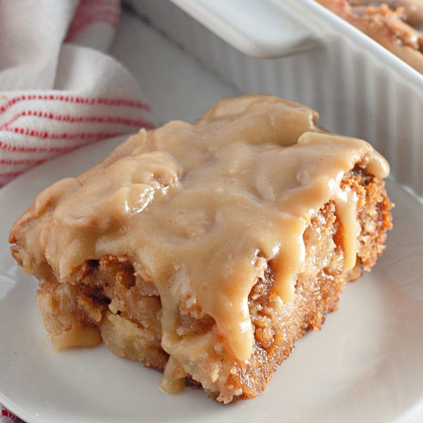 A beautifully presented full apple dapple cake with a shiny caramel glaze.