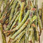 Golden and crispy roasted green beans topped with Parmesan cheese and garlic for a flavorful side dish.