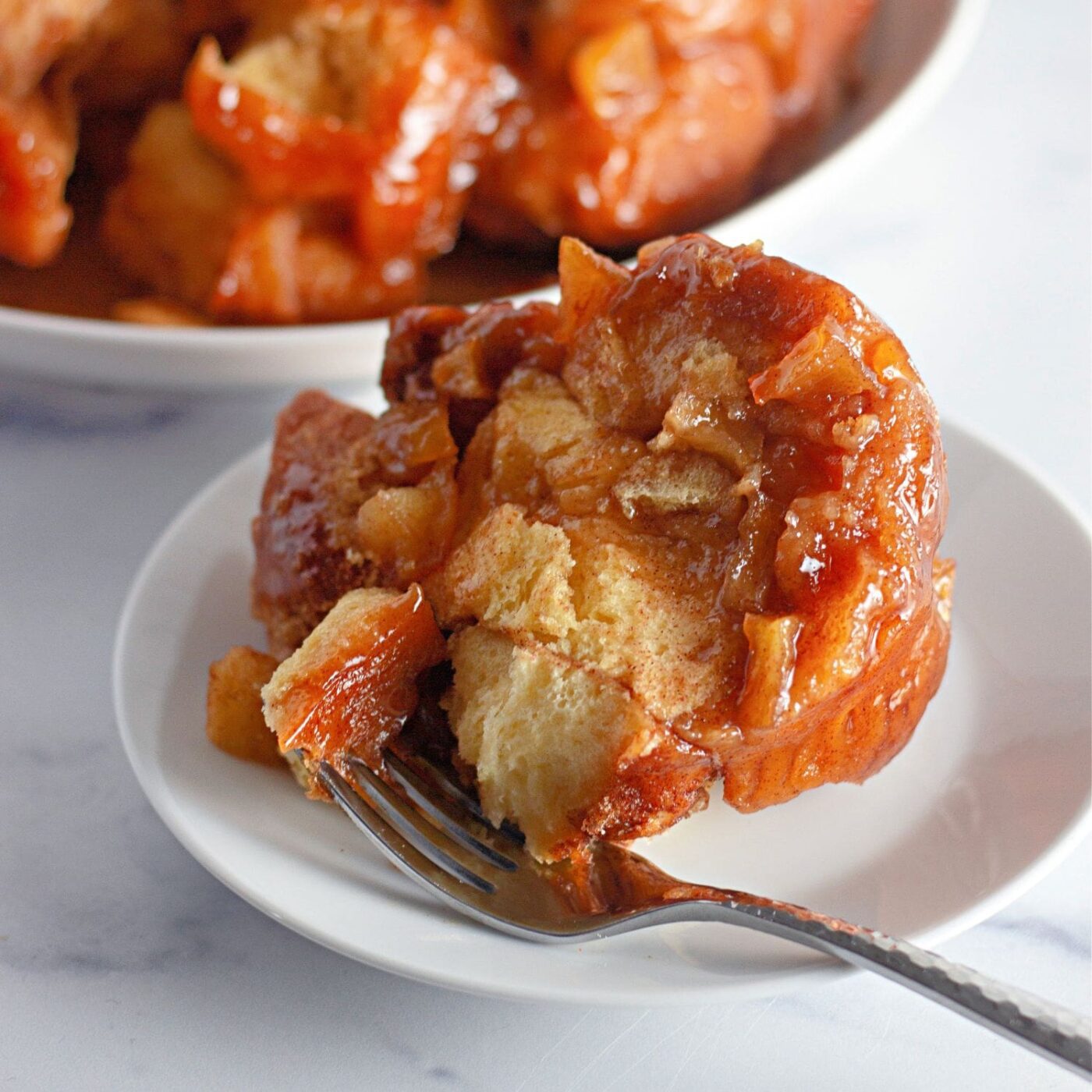A wide, inviting shot of a fully baked and glazed apple fritter monkey bread.