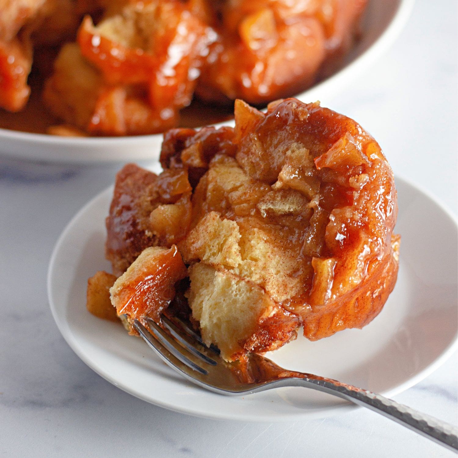A wide, inviting shot of a fully baked and glazed apple fritter monkey bread.