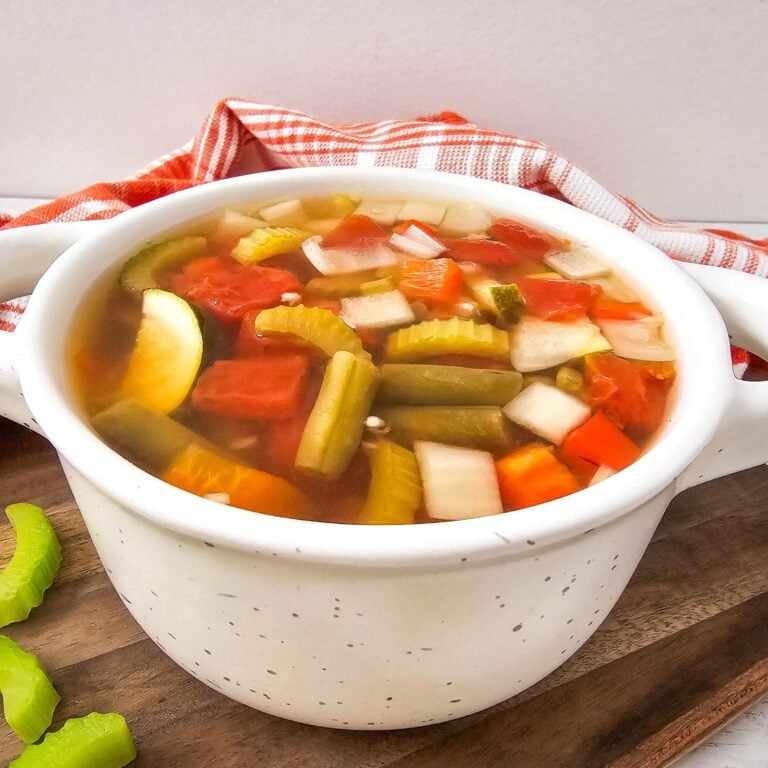 A large, inviting photo of light and easy crockpot summer vegetable soup in a bowl.