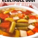 A bowl of vibrant vegetable soup with herbs, ready to be served.