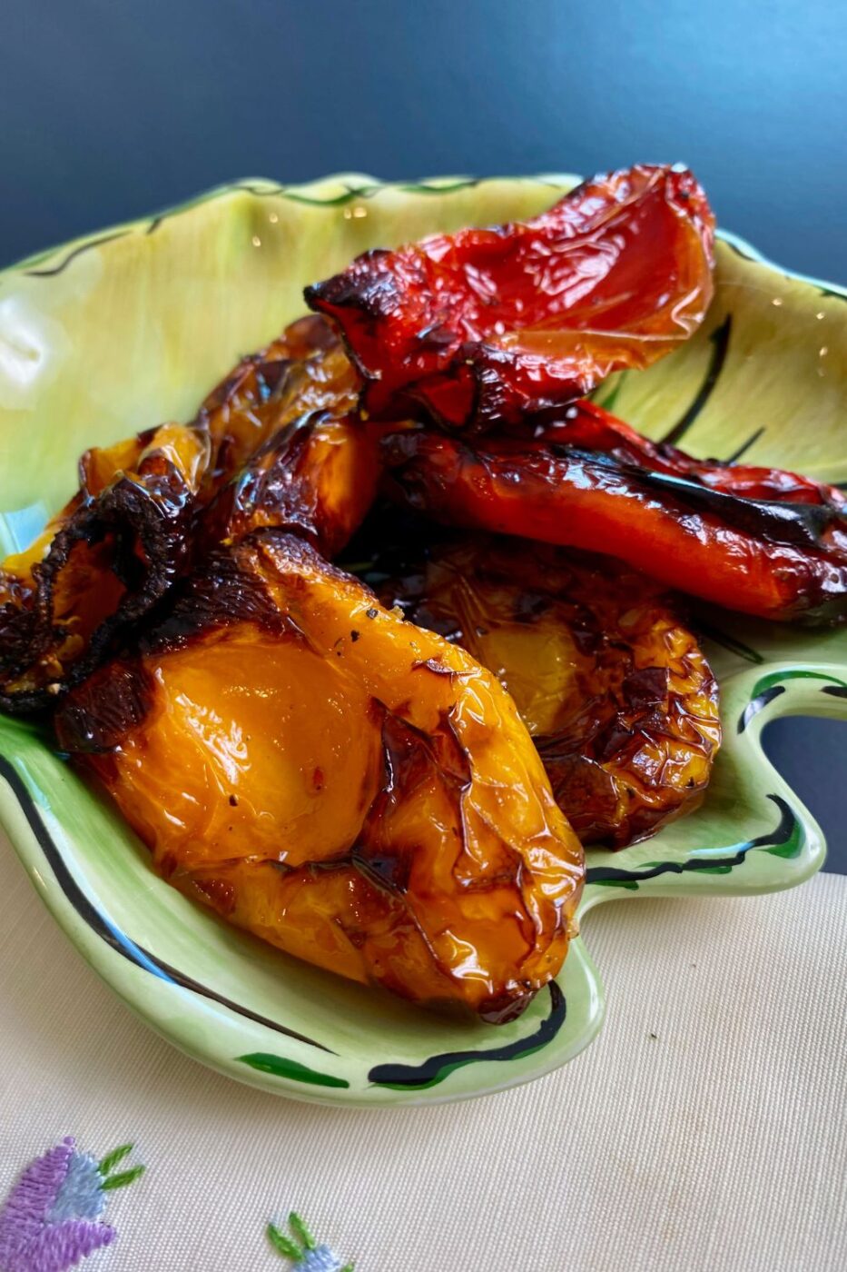 A vibrant bowl of roasted mini bell peppers with visible char marks, cooked in an air fryer.