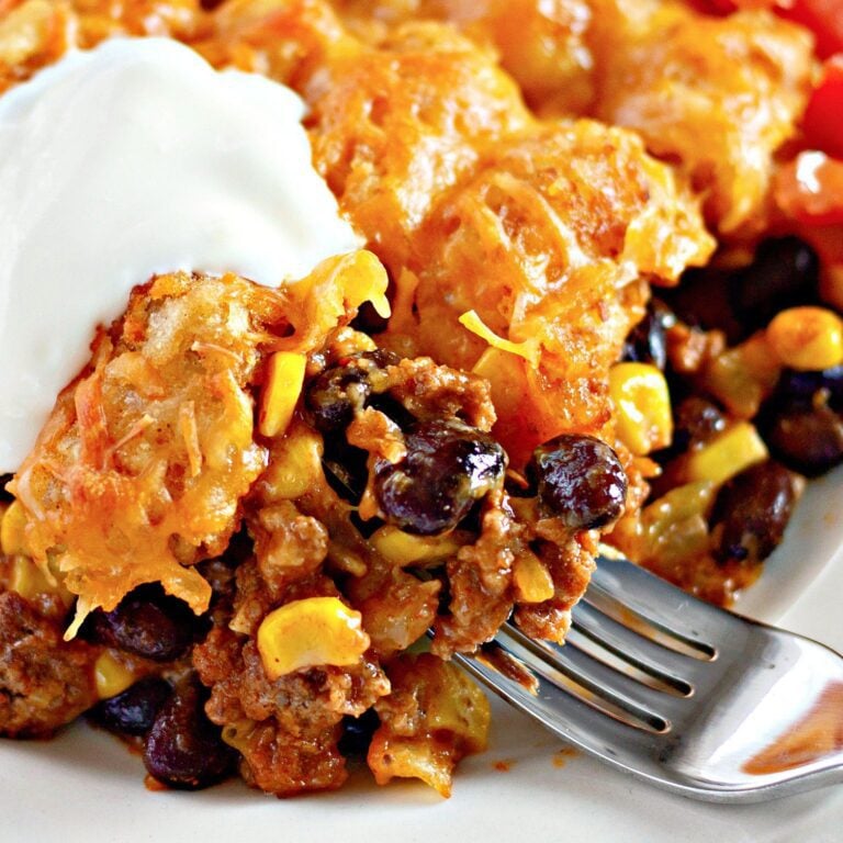 A large, inviting photo of a bubbly, golden-brown enchilada tater tot casserole.