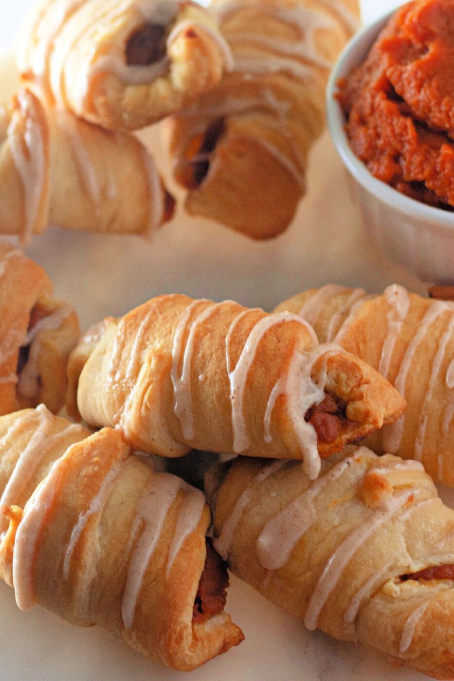 Pumpkin-filled crescent rolls fresh out of the oven on a baking sheet.