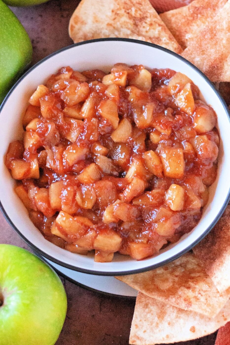A bowl of warm apple dip with crispy cinnamon tortilla chips.