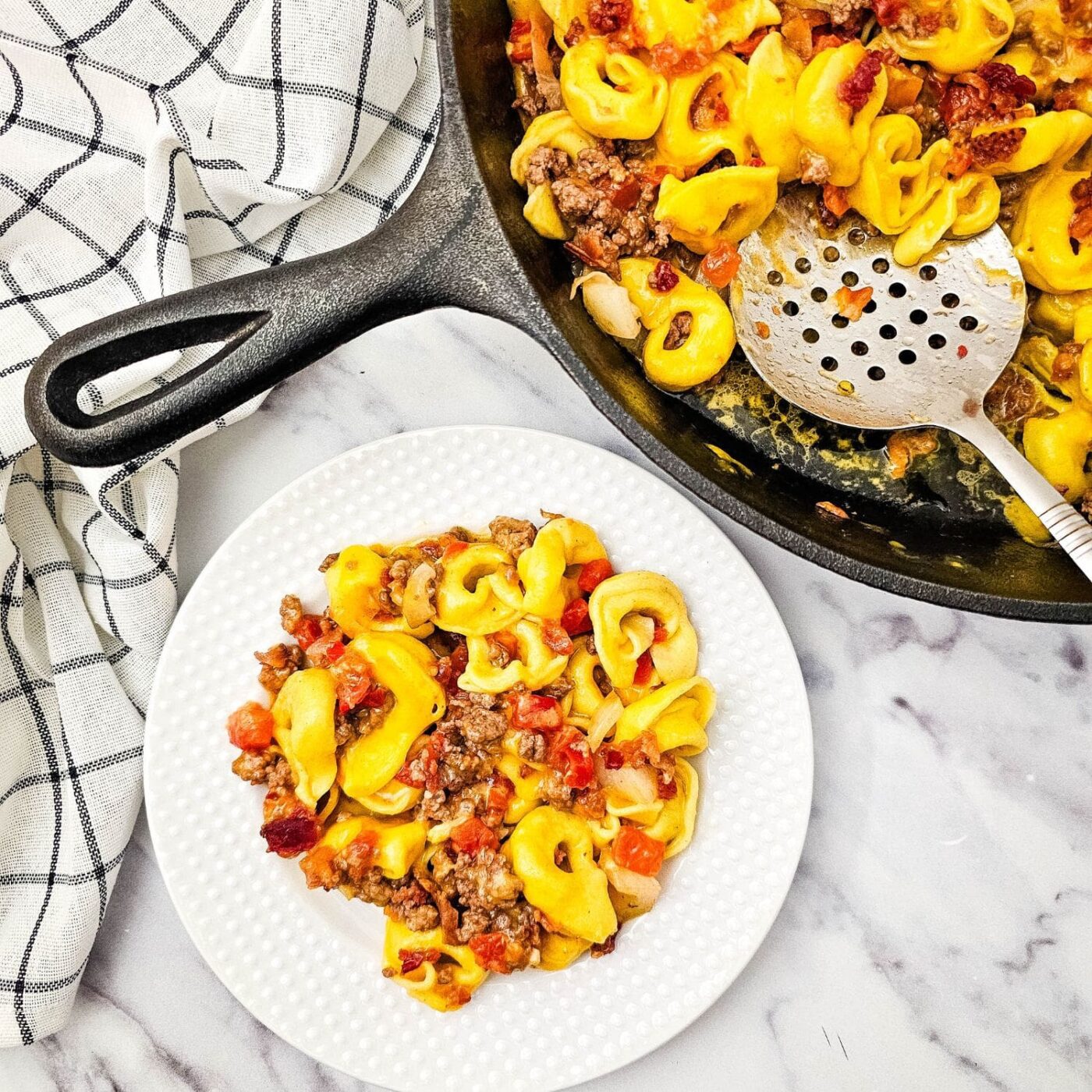 Hero image of skillet bacon cheeseburger tortellini with melted cheddar cheese.