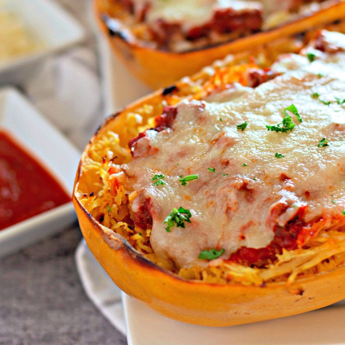 Stuffed spaghetti squash served with melted cheese and garnish