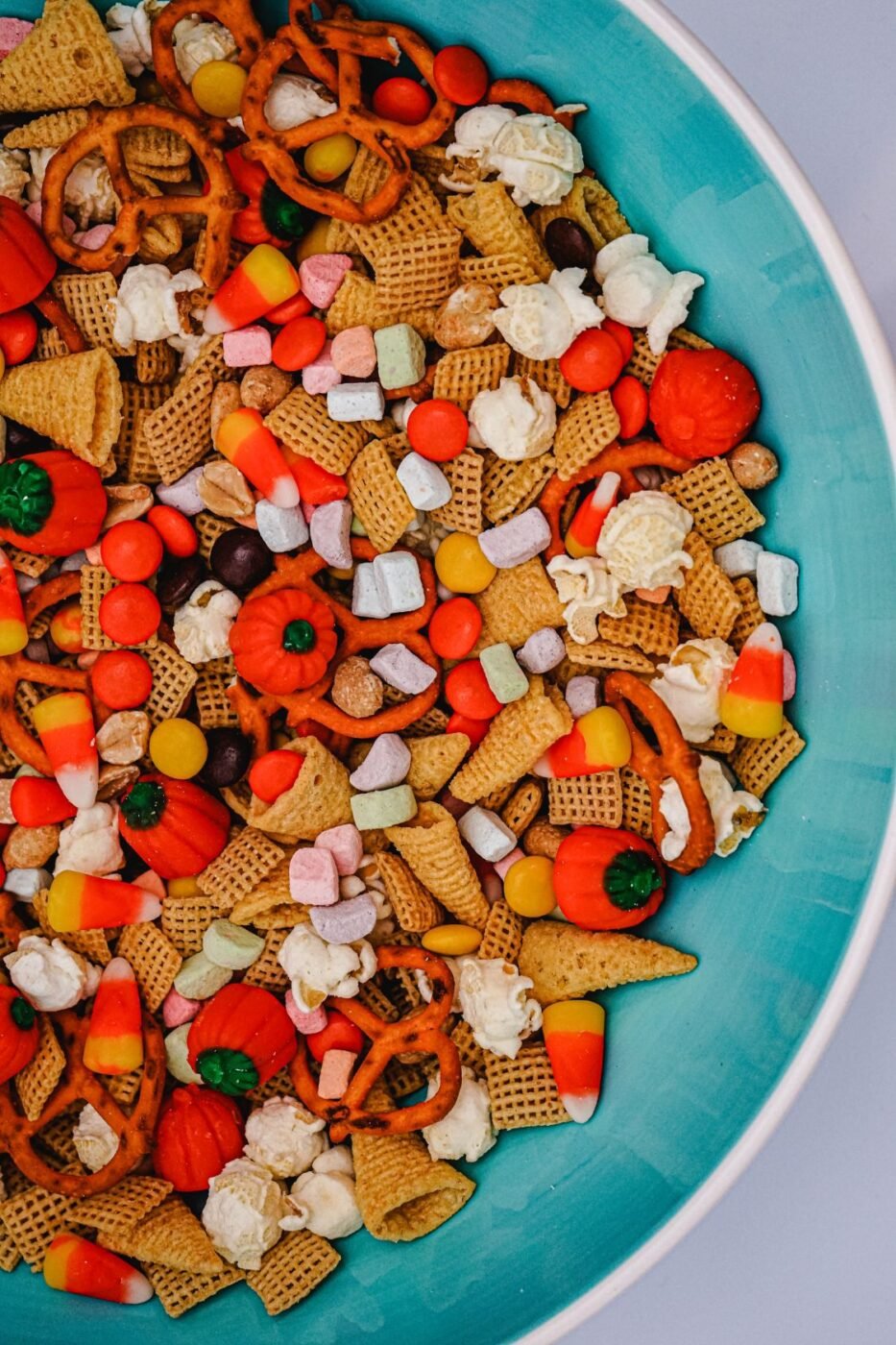Halloween-themed snack mix with candy corn, pretzels, and popcorn.