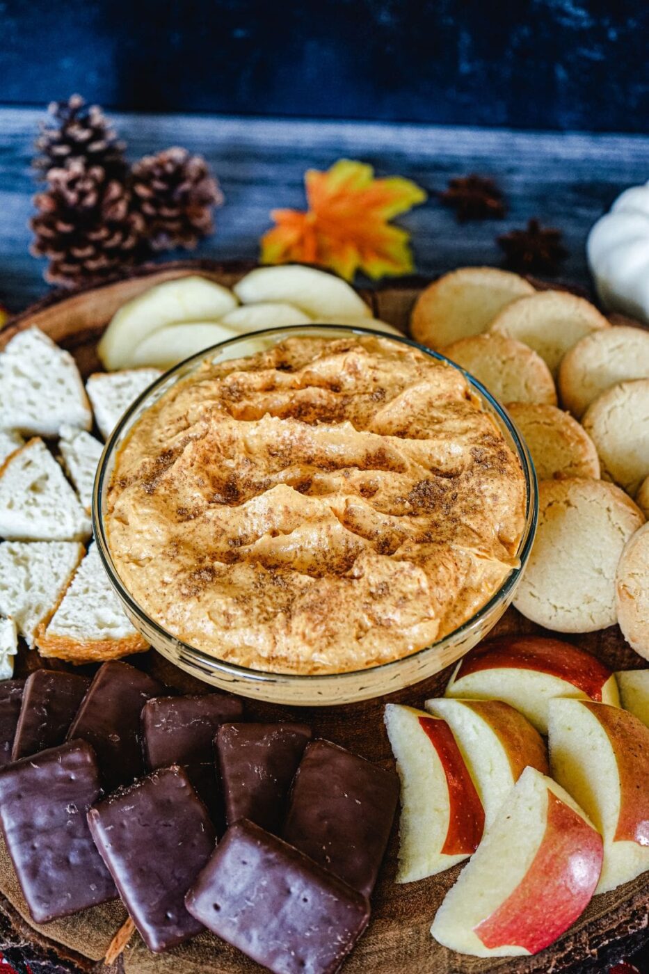 Bowl of pumpkin fluff surrounded by cookies and pretzels.