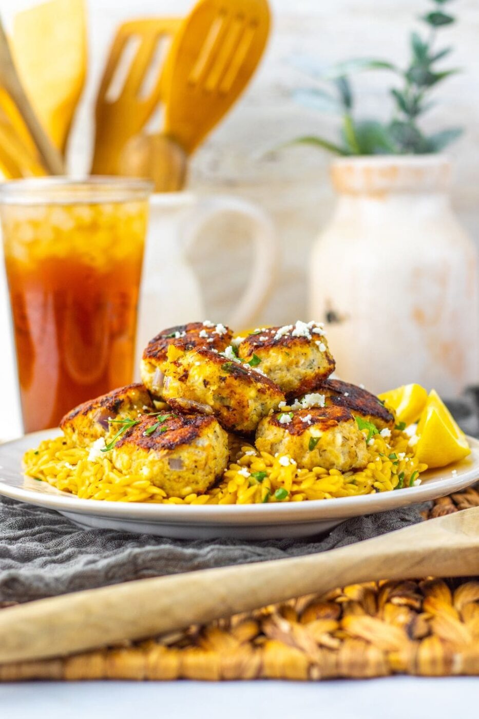 Golden brown chicken meatballs on lemon orzo pasta with parsley garnish.
