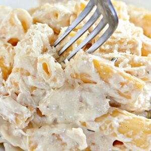 Slow cooker rigatoni Alfredo pasta served in a white casserole dish.