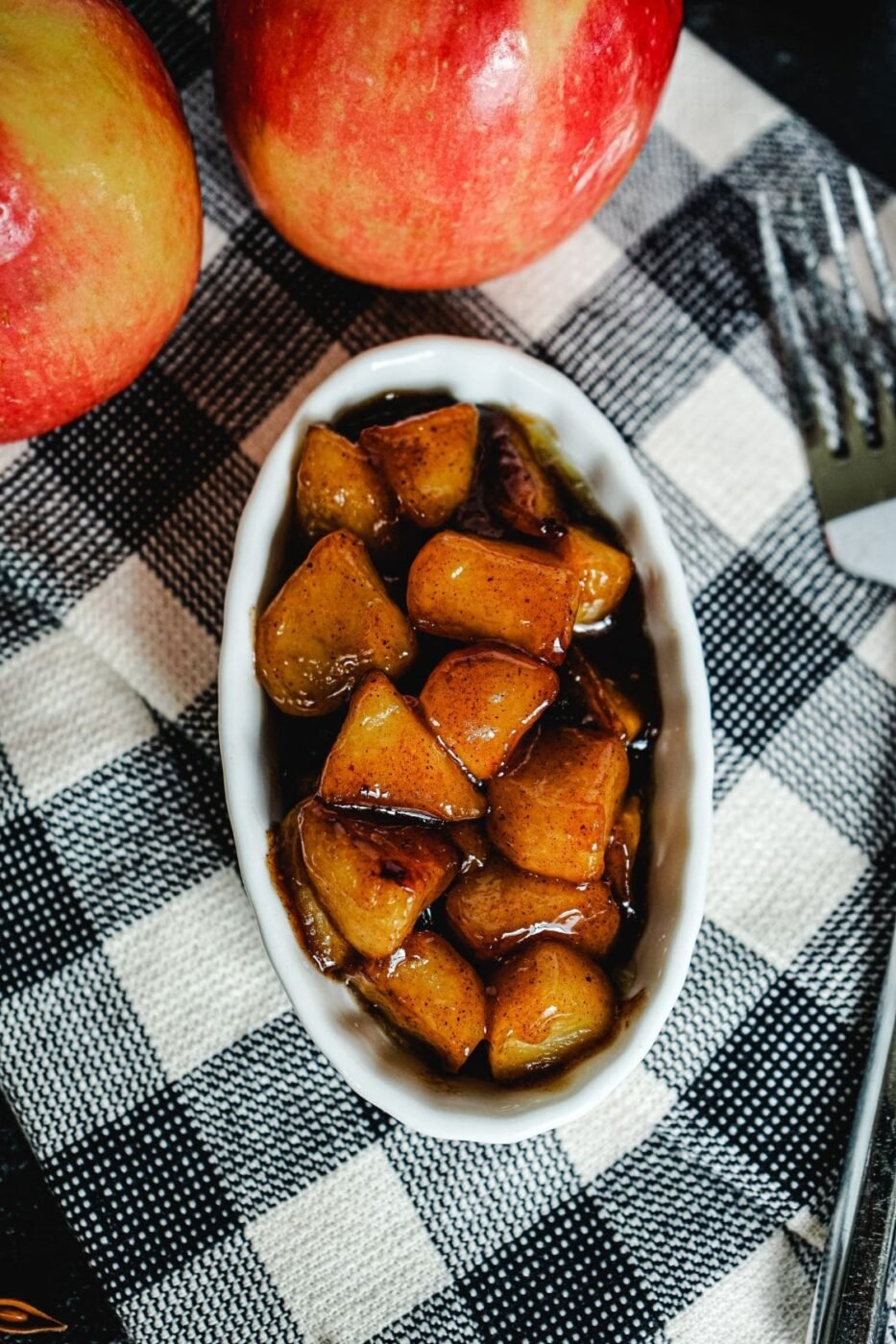 Sautéed apple slices in a skillet with cinnamon and butter.