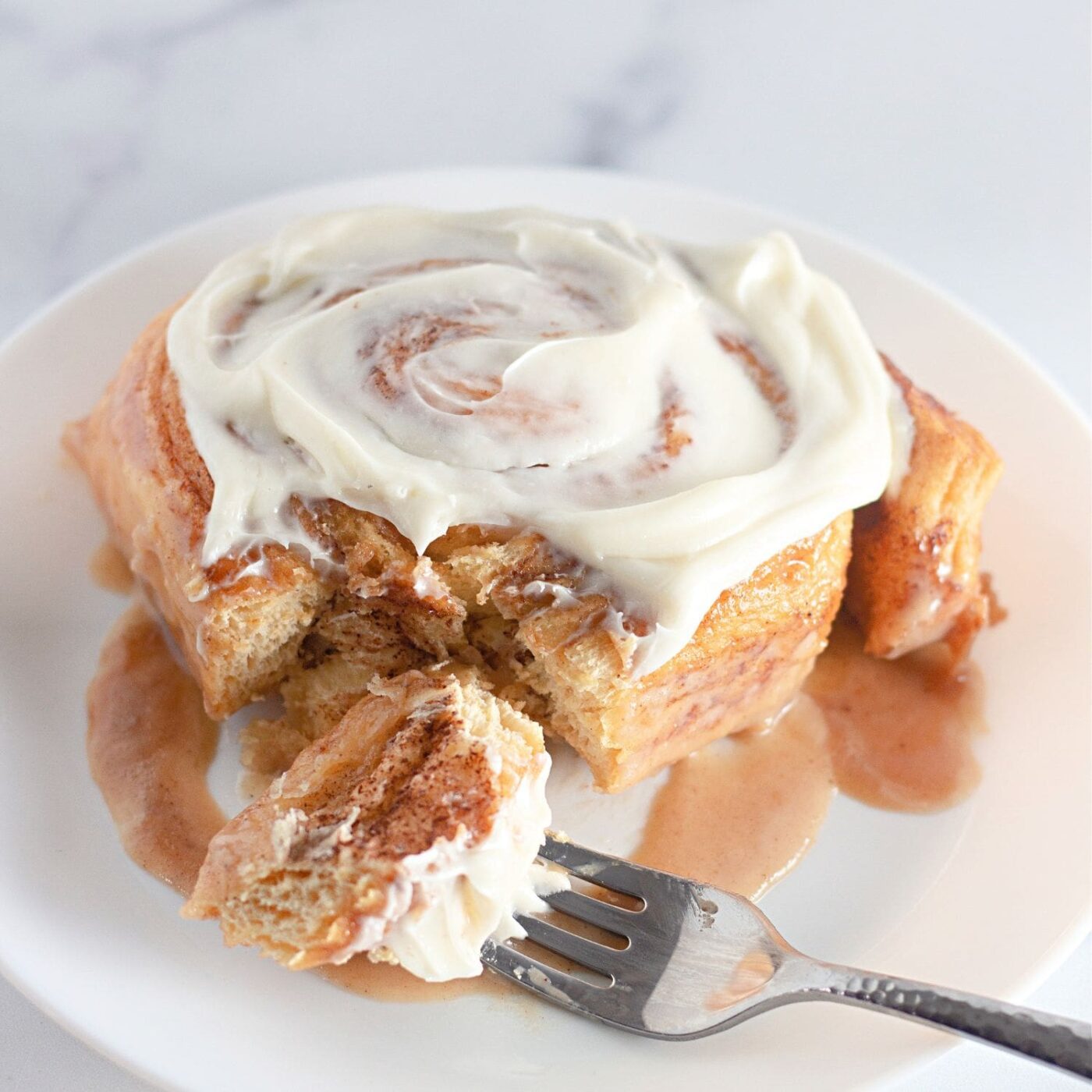 Featured image of TikTok cinnamon rolls in a pan with cream cheese frosting.