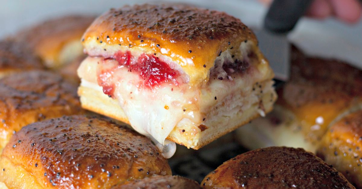 Turkey and cheese sliders topped with a shiny buttery glaze, ready to serve.