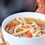 A white bowl of homestyle chicken noodle soup