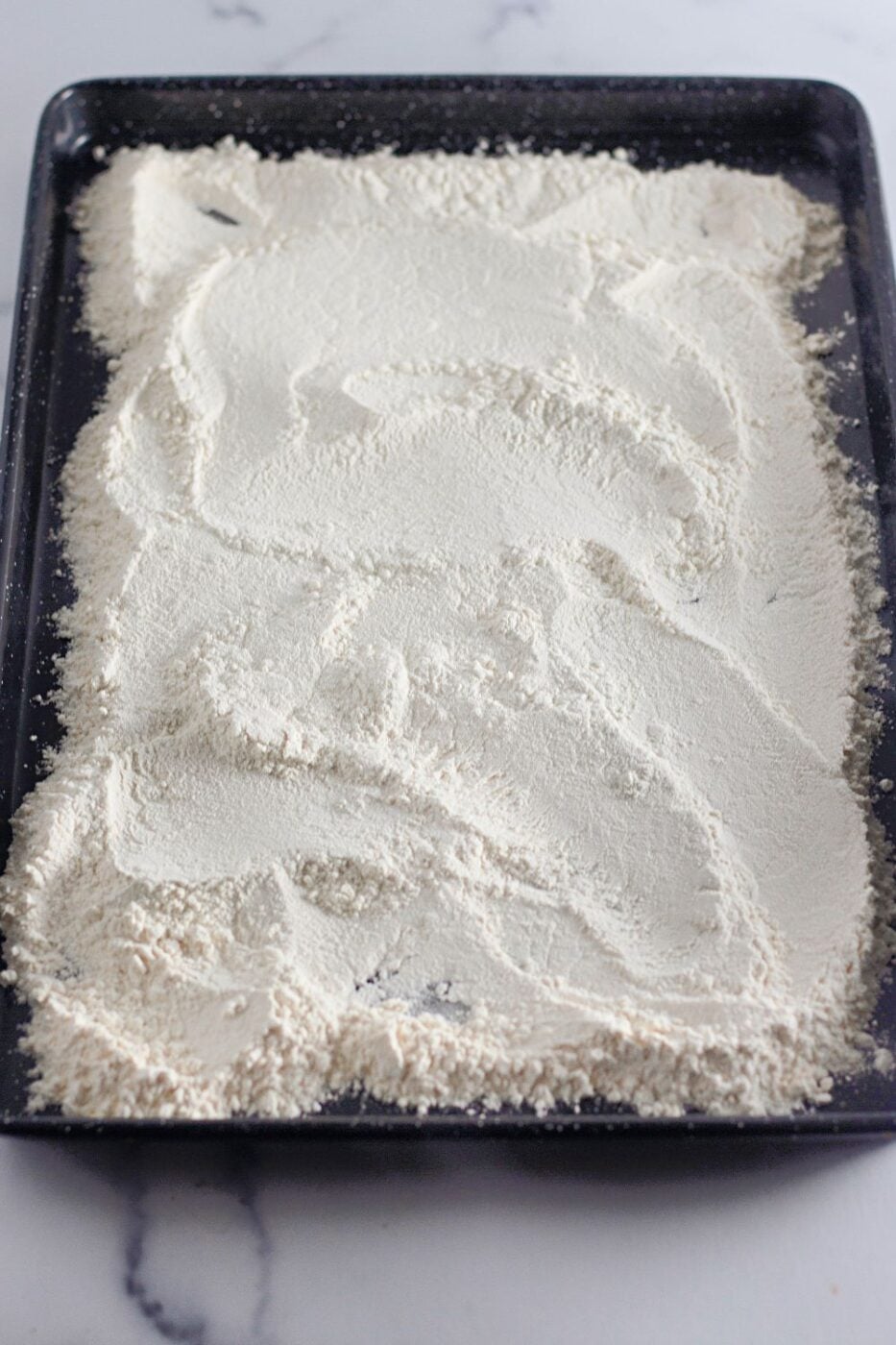 Heat-treated flour spread on a baking sheet.