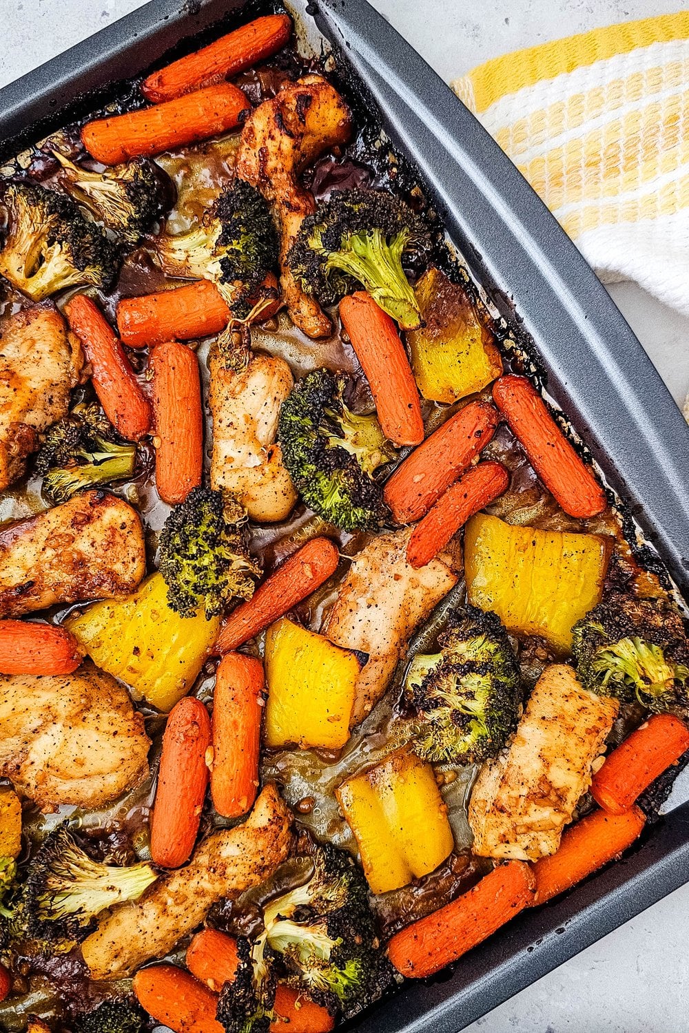 Honey garlic chicken with broccoli, carrots, and bell pepper roasted on a sheet pan