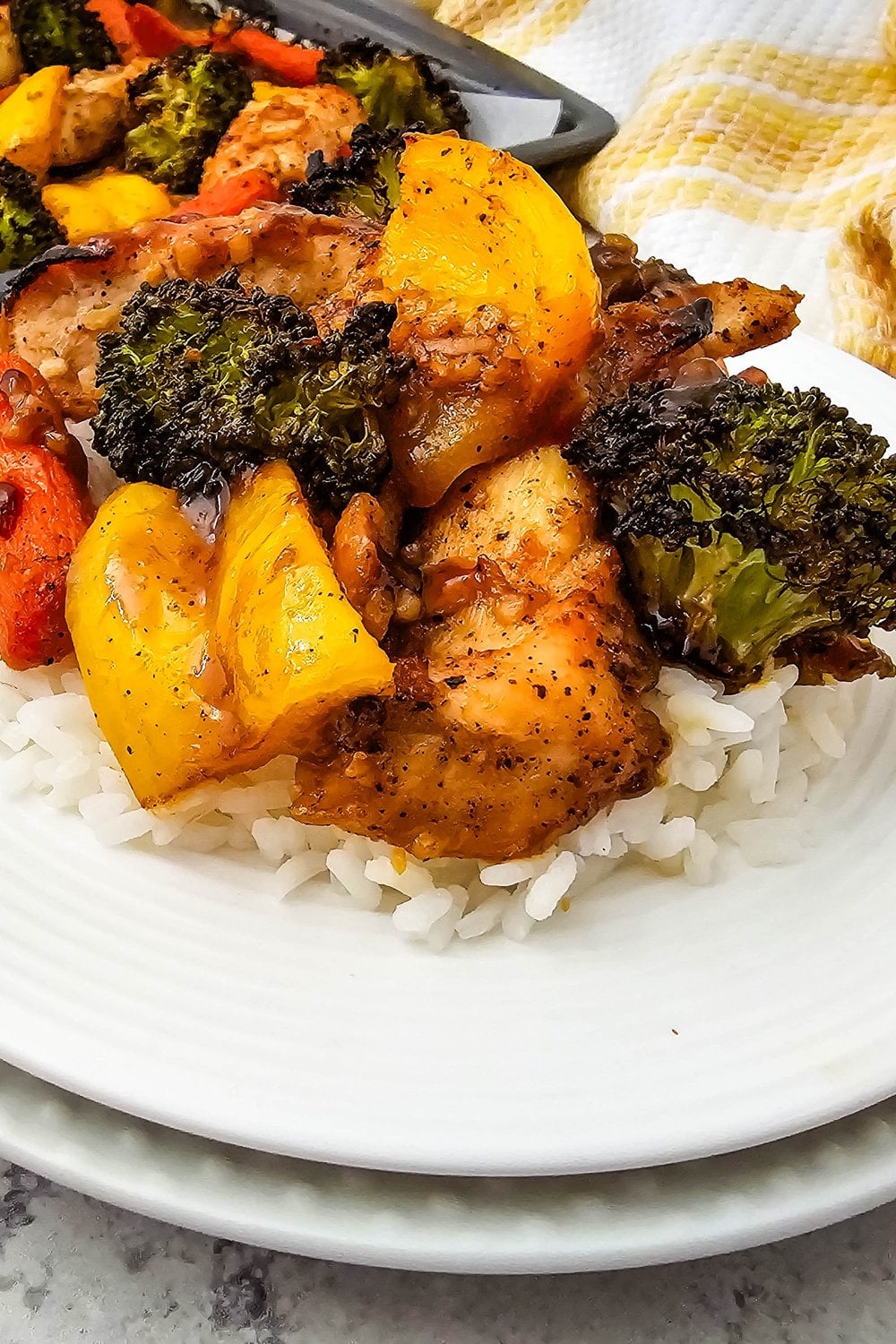 Plate of honey garlic chicken and roasted vegetables over rice