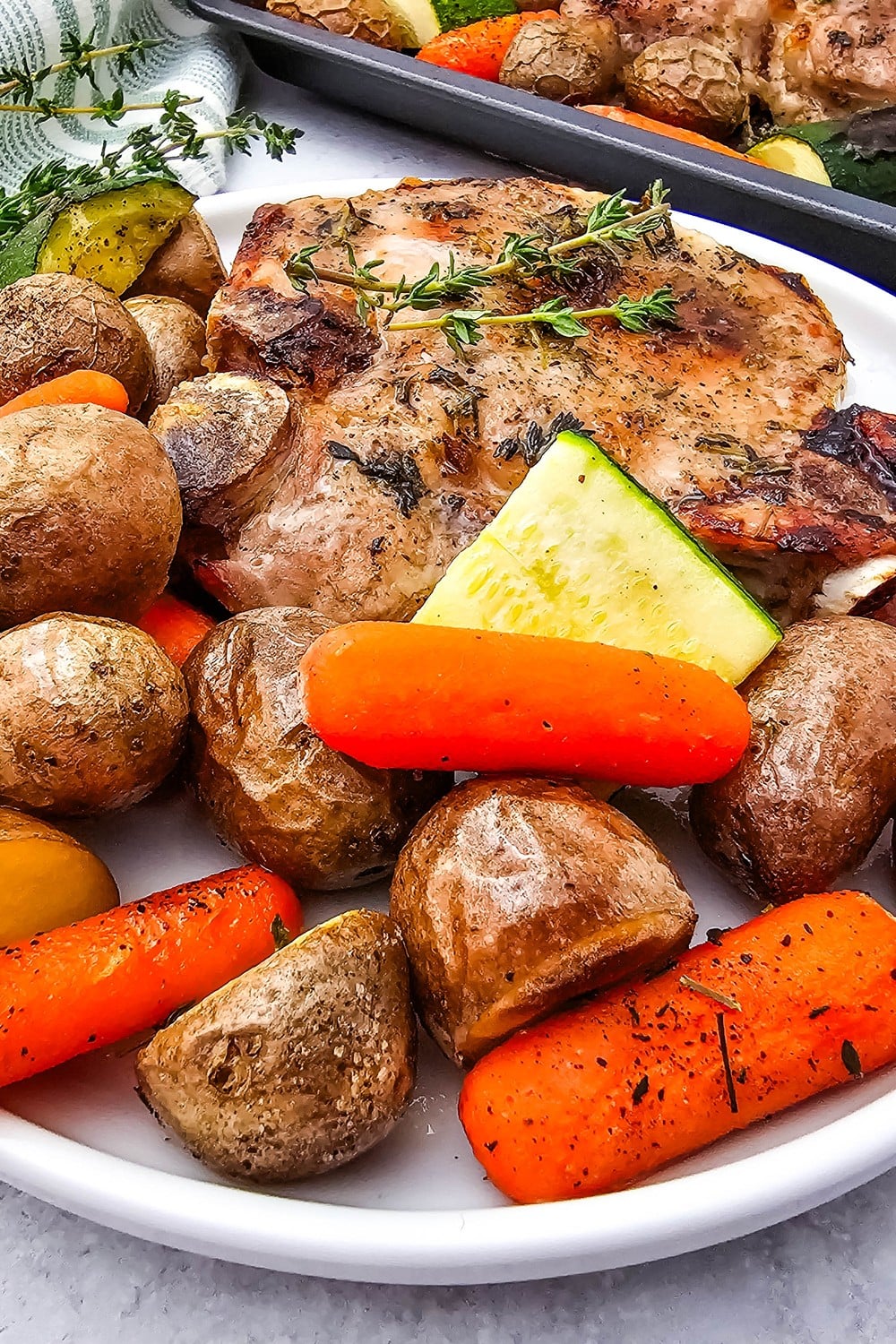 Close-up of honey glazed pork chops showing caramelized glaze with roasted carrots and potatoes