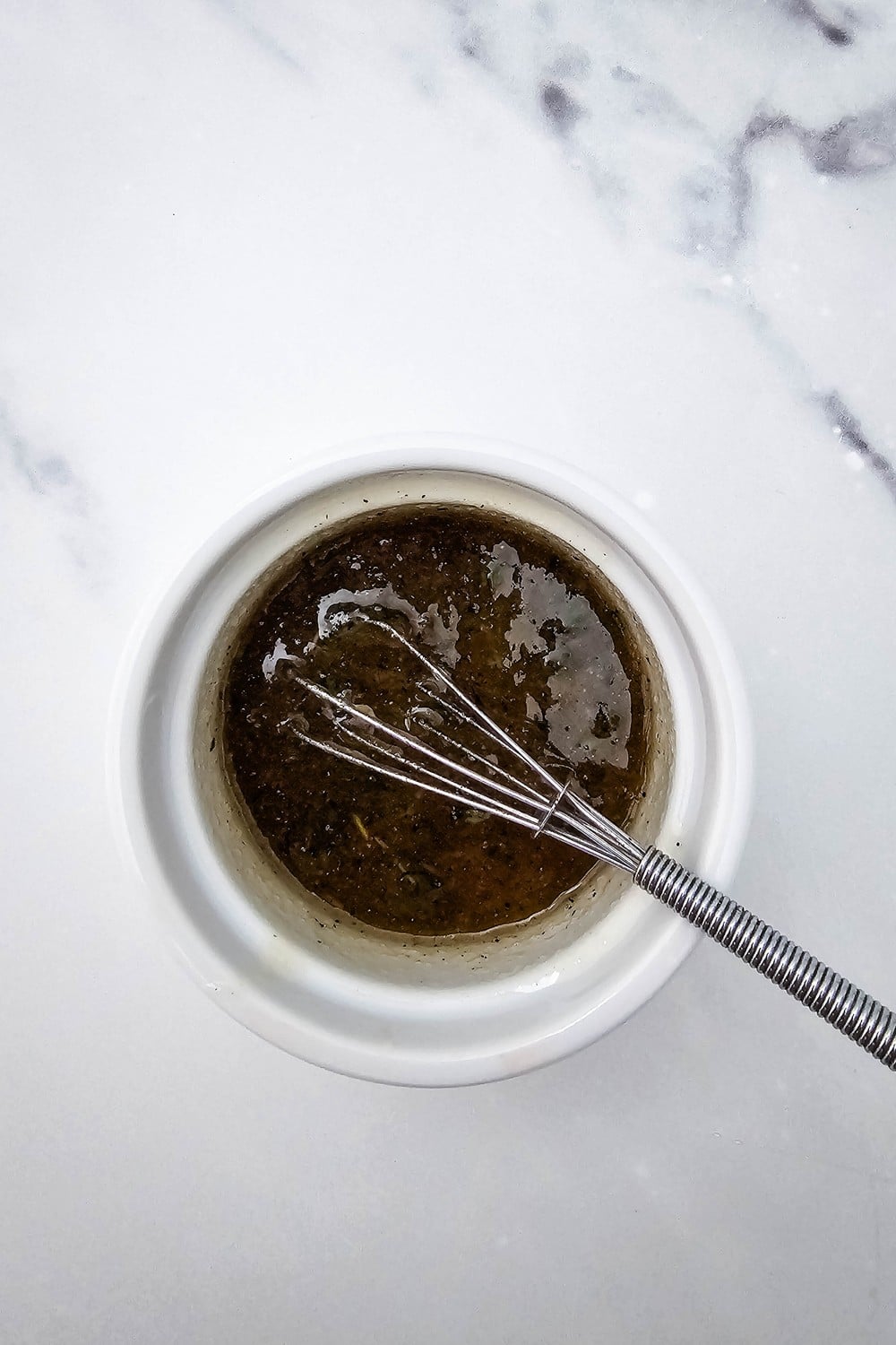 Honey and fresh thyme glaze whisked together in small white ramekin