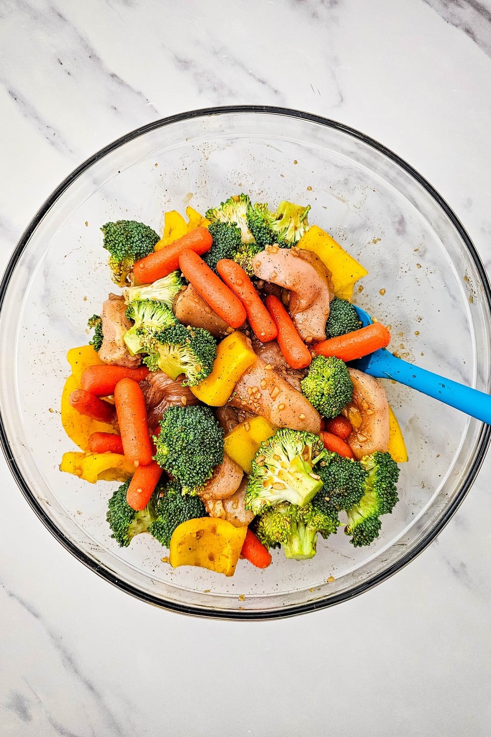 Chicken and vegetables tossed together in honey garlic sauce in a glass bowl