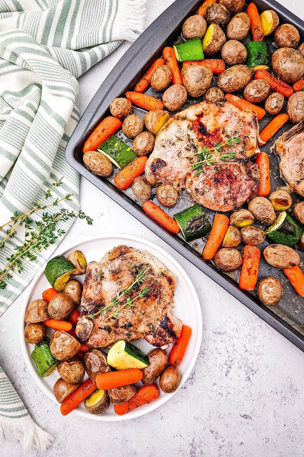 Overhead view of sheet pan honey glazed pork chops with roasted vegetables and plated serving on white plate