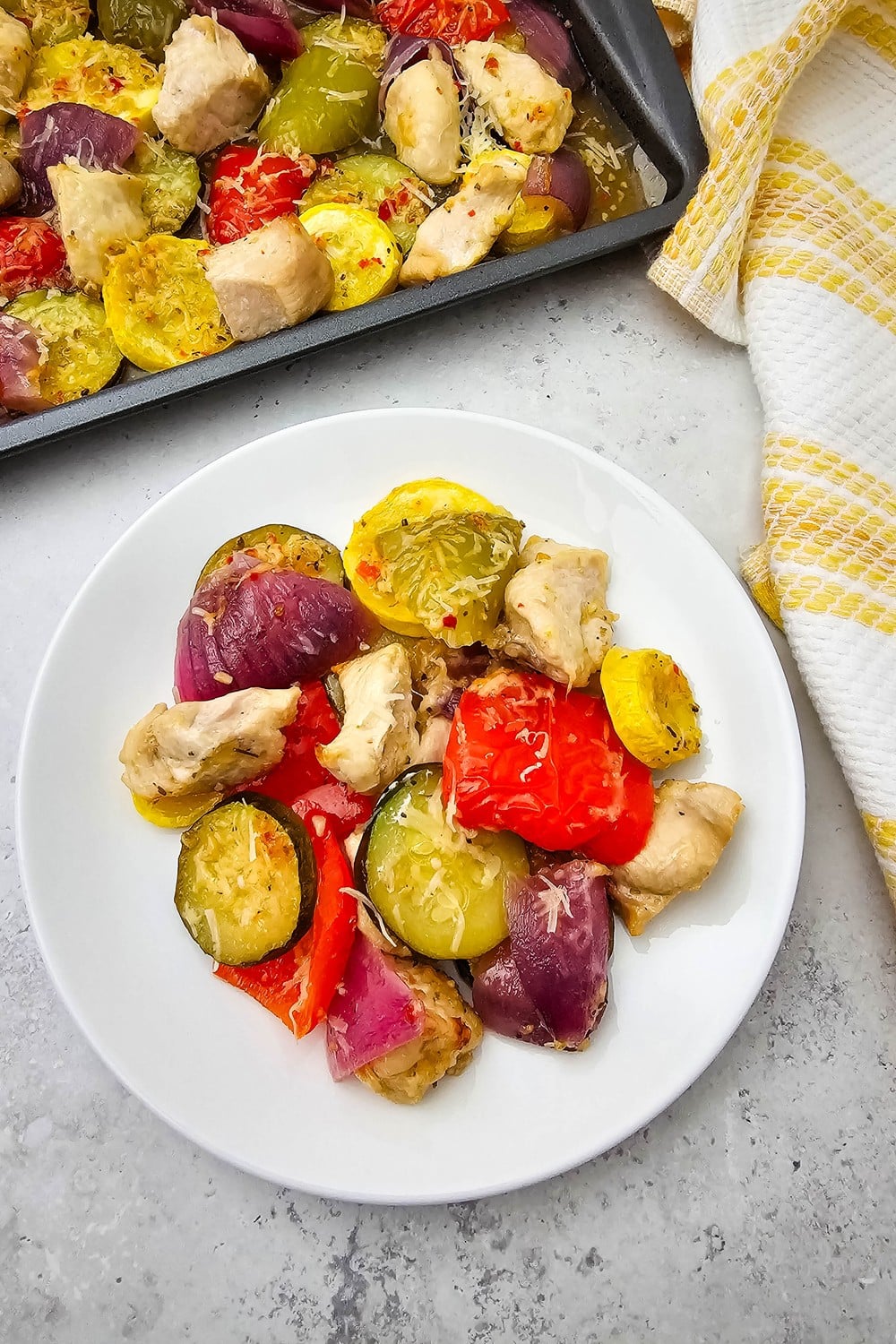 Roasted Italian chicken and veggies served on white plate