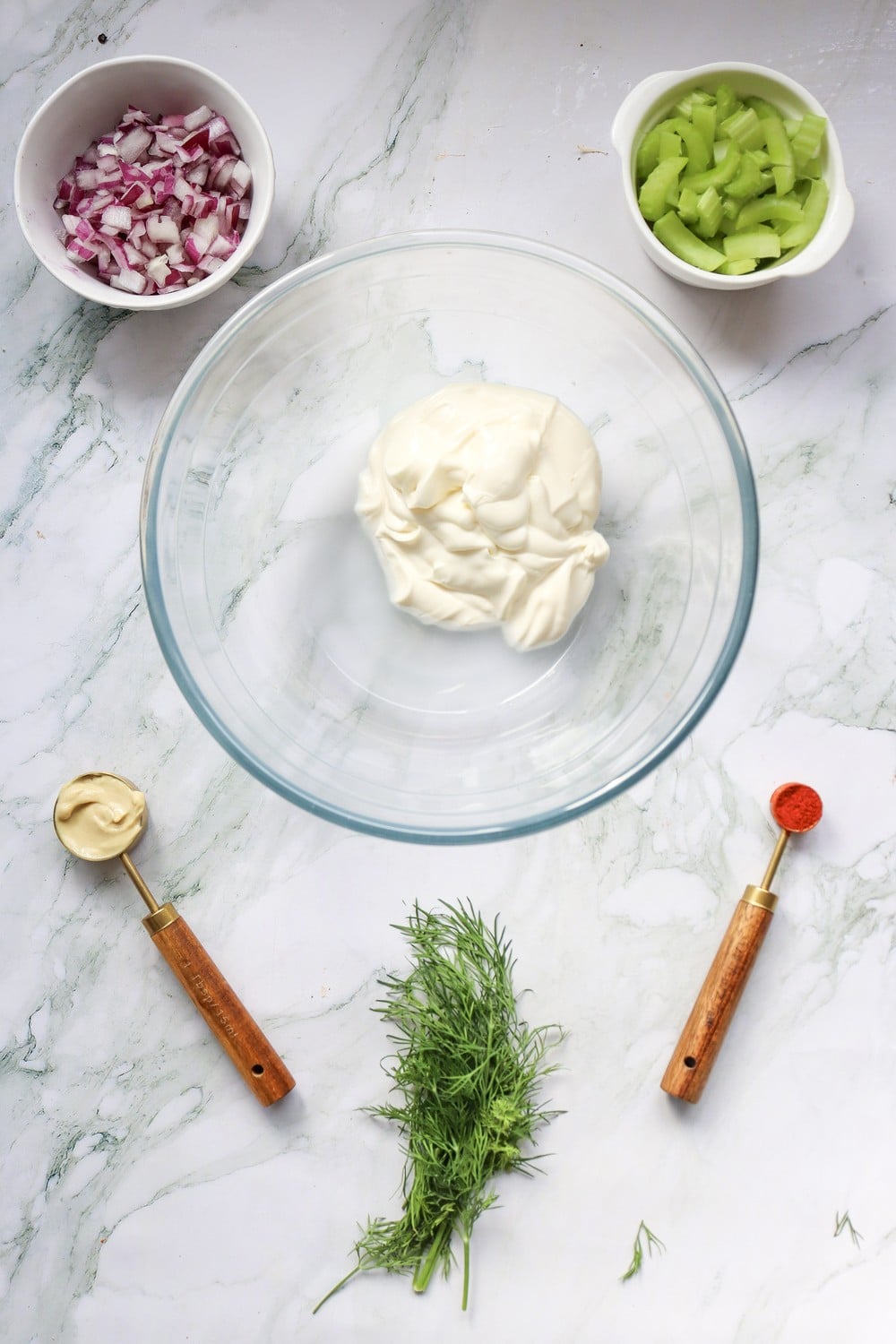Mise en place for the 4th of July potato salad dressing: mayo, Dijon, paprika, and dill in white bowls